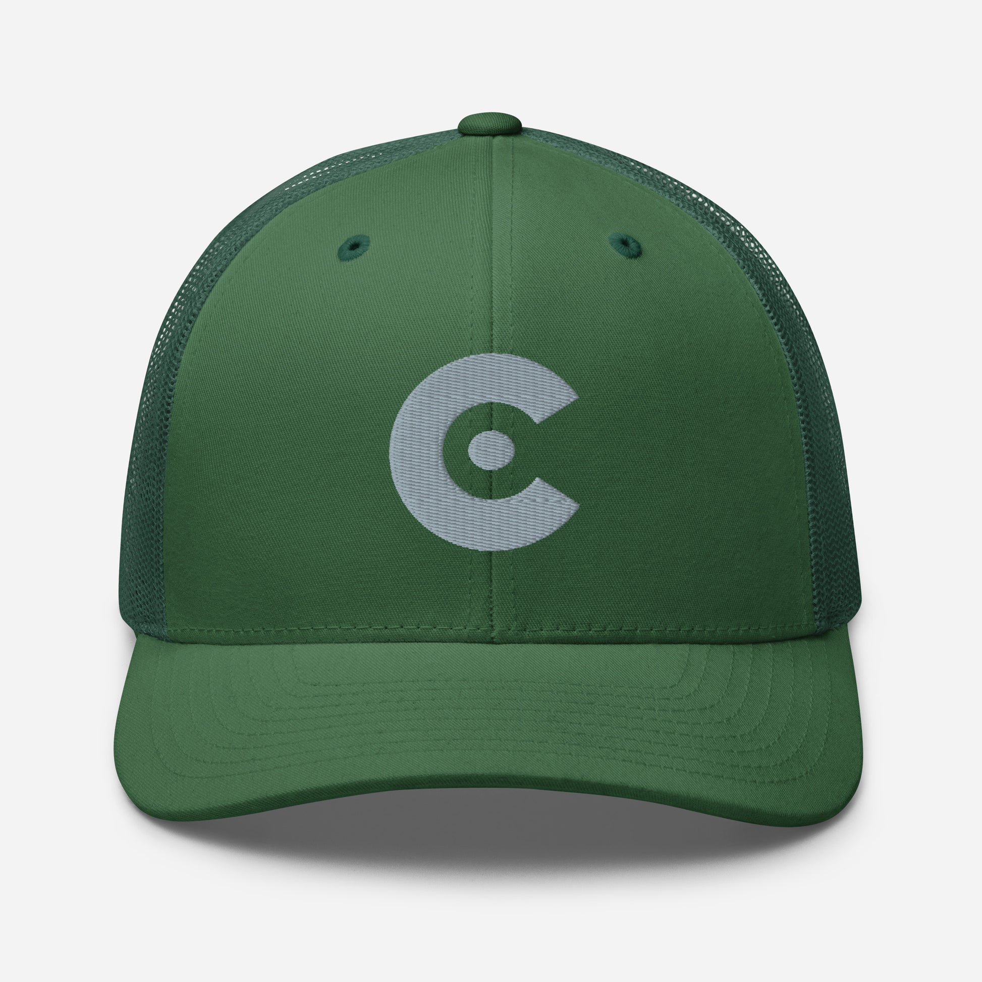 A dark green trucker-style baseball cap with a curved brim and dark green mesh back panels, featuring a light gray embroidered circular 'C' logo on the front panel.