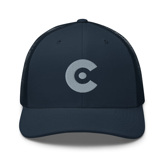 A dark navy CobbleRose blue trucker hat with a structured front panel and mesh back, featuring a light gray circular 'C' logo on the front, set against a plain white background.